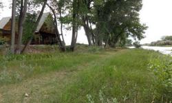 Looking for that log home on the river with irrigated land? Here it is! Two parcels containing 22.11 & 2.52 acres with a log home built in 2000 with extra-large logs and a log-sided gate house built in 1945. There are 3 shares of Bonafide Ditch irrigation