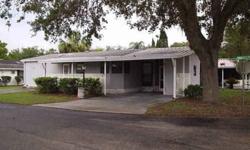 This very nice double-wide mobile home is located in Sandalwood Mobile Home community on the west side of Zephyrhills, Florida. It has 2 bedrooms, 2 baths, a Florida Room, a carport and a utility/laundry room. It occupies a nice tree-shaded corner lot.